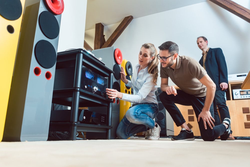 Young,Couple,,Woman,And,Man,,Buying,High-end,Stereo,Equipment,In