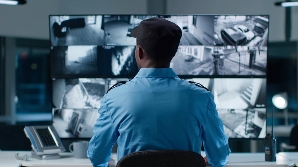 Back,View,Of,African-american,Security,Operator,Use,Computer,With,Screens